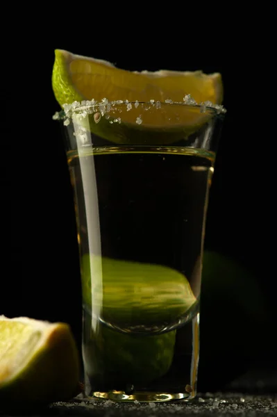 Tequila messicana Oro in vetro con fette di lime e sale. — Foto Stock