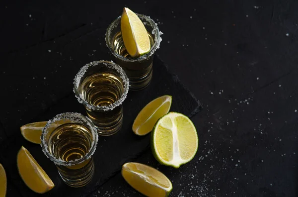 Tequila de ouro mexicano com fatias de limão e sal, vista superior — Fotografia de Stock