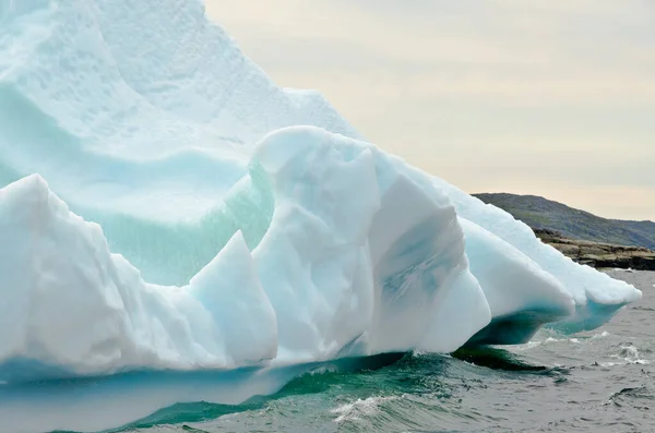 Leuchtend Weißer Eisberg Auf Dunklem Wasser Und Felshintergrund — Stockfoto