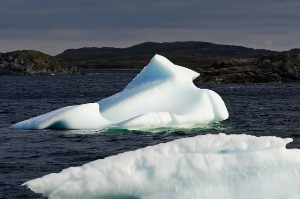 Leuchtend Weißer Eisberg Auf Dunklem Wasser Und Felshintergrund — Stockfoto