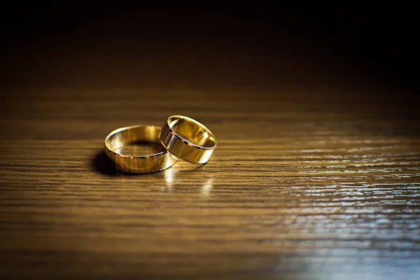 Gold wedding rings on a wooden table