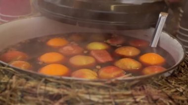 Elma ve portakal ile bir tencerede mulled şarap. Sıcak bir içecek. Meyve iç. Gıda adil. Sokak gıda.