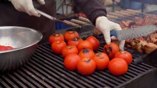 Kuchař se změní přes rajčata na grilu. — Stock video