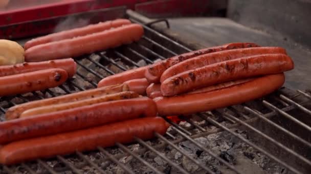 Сосиски для хот-догов жарят на гриле — стоковое видео