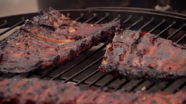 A man prepares pork ribs on the grill — Stock Video