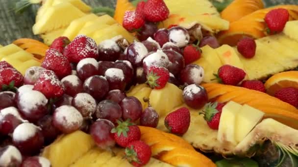 Sortiment an frischen Früchten. Erdbeere, Ananas, Trauben, Puderzucker. — Stockvideo