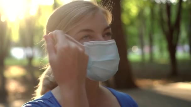 Γυναίκα Αφαιρεί Μια Ιατρική Μάσκα Ένα Πάρκο — Αρχείο Βίντεο