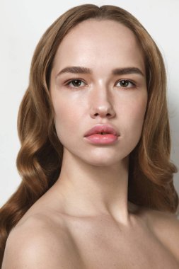 Uzun kıvırcık saçlı ve temiz makyaj genç güzel kadın