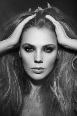 Siyah beyaz portre uzun saçlıve dumanlı göz makyajı ile genç güzel kadın