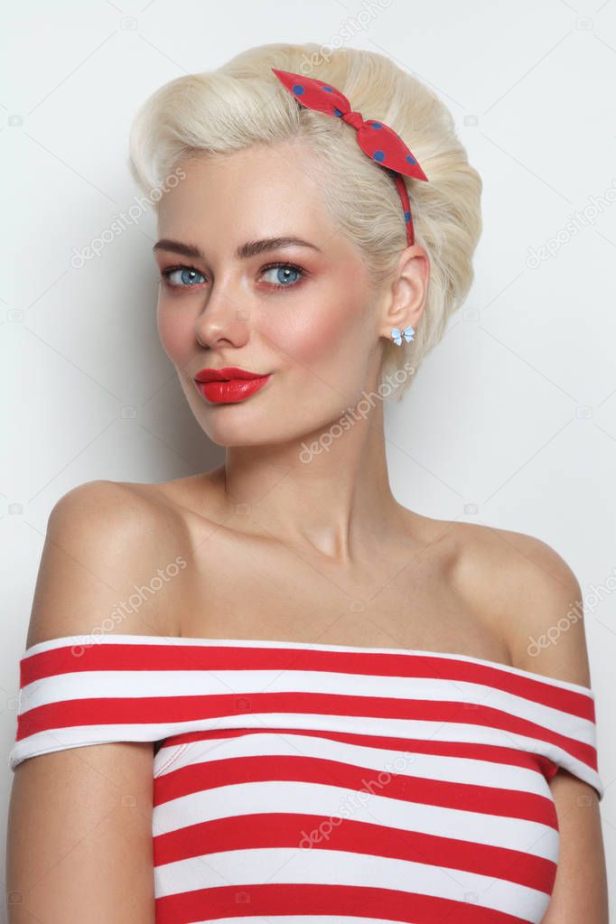Vintage style portrait of young beautiful blond woman in striped