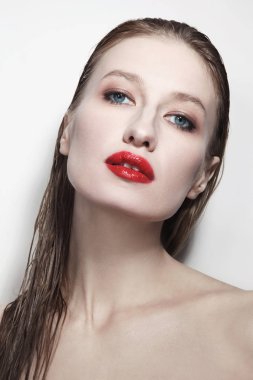 Beyaz arka planda ıslak saçlı ve kırmızı dudaklı genç göz alıcı kadın portresi