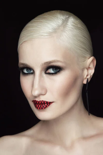 glamorous woman with smoky eye makeup and fishnet red lips on black background