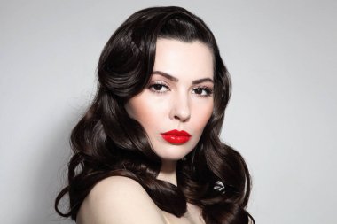Uzun kıvırcık saçlı ve kırmızı rujlu güzel bir esmer.