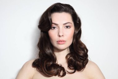 Uzun kıvırcık saçlı ve çıplak makyajlı güzel bir esmer.