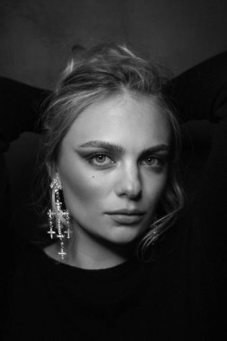 Sarışın ve süslü küpeli güzel bir kadının klasik siyah beyaz portresi.