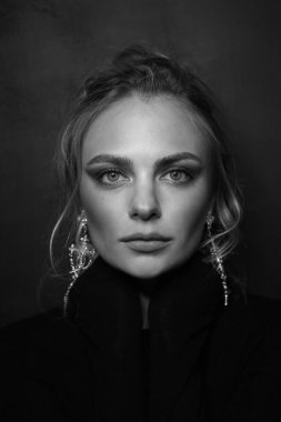 Sarışın ve süslü küpeli güzel bir kadının klasik siyah beyaz portresi.