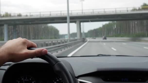 Man zijn auto rijden. Rijdende auto op vakantie, natuur. Mannenhand op stuurwiel close-up. 4k — Stockvideo