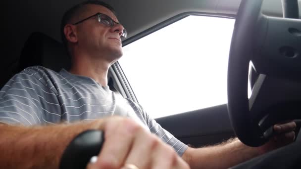 Un hombre mayor conduce un coche en la autopista. Un hombre conduciendo su coche en vacaciones. 4k — Vídeo de stock