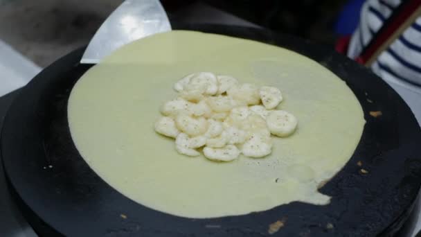 Vendeur de crêpes aux frites aux bananes dans le marché nocturne vietnamien. Nourriture asiatique. 4k — Video