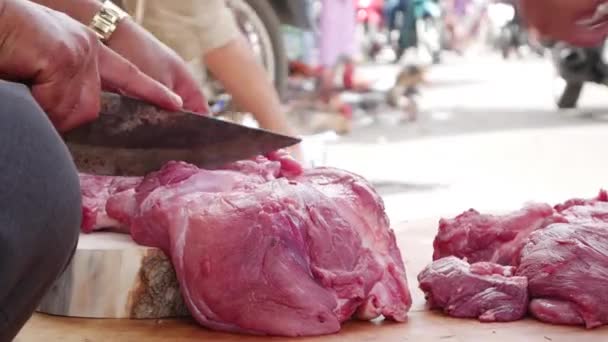 Primer plano de un carnicero cortando carne para un comprador en el mercado local — Vídeos de Stock