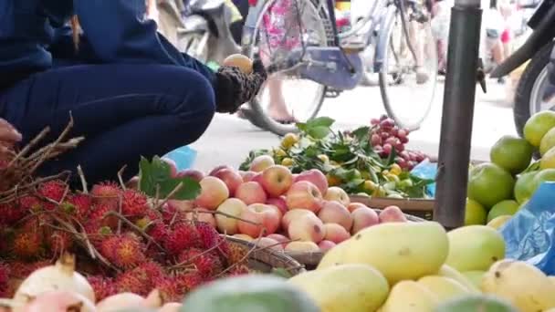 Закрыть женскую руку сортирует фрукты в корзине на местном рынке — стоковое видео