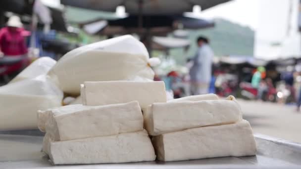 Крупный план белый веганский тофу на продажу на подносе на местном рынке — стоковое видео