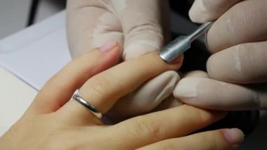 Closeup manikürcü cuticles üzerinde çivi geri iter ve jel tırnak cilası uygulama için hazırlar. Güzellik spa salonu Manikür yapıyor kadın