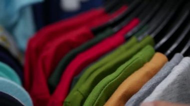 Yeni giysiler seçmek Closeup genç güzel kadın moda alışveriş merkezinde alışveriş