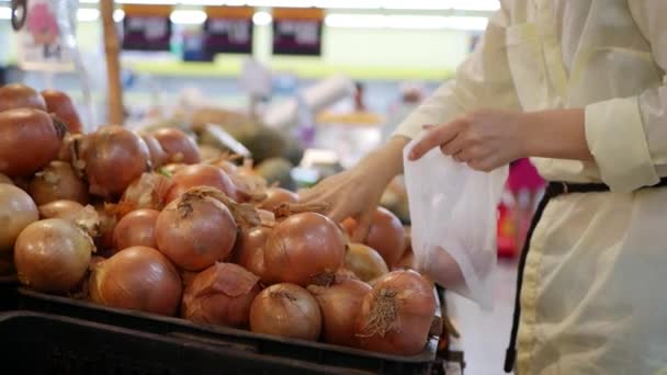 Femmes main choisissant les oignons frais dans le supermarché — Video