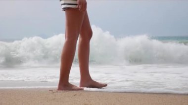 Kadın çıplak ayak yaz sahilde yürüyüş. Deniz suyu ve kum dalga sahilde yürüyen genç kadın bacak kadar kapatın.