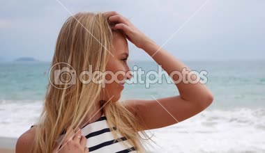 Neşeli genç güzel kız deniz fırtınası vasıl geçmiş üzerinden kameraya bakarak göz kırpıyor gülümseyen