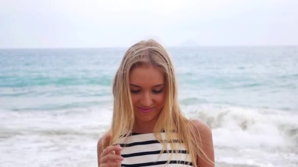 Młody, atrakcyjny, sexy kobieta patrzy się na aparat i uśmiechów na tle w czasie burzy na morzu. Piękna kobieta wesoły, chodzenie na tropikalnej plaży. — Wideo stockowe