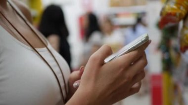 Alışveriş merkezinde akıllı telefon ile kadın eller. Teknoloji konsepti. Kız dokunuşunda ekran