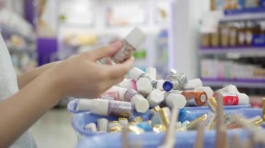 Kadının el seçimi ve oje Güzellik Salonu içinde satın alma. Kozmetik tutan bir kadın