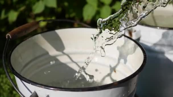 Pouring the water into metal bucket, 4k footage, closeup — Stock Video