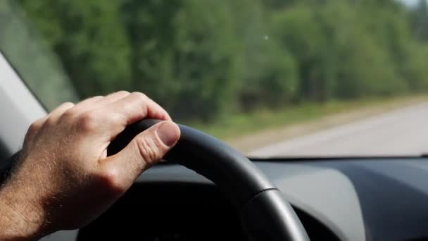 Un hombre conduciendo su auto. Conducir coche en vacaciones, la naturaleza. Hombre Mano en el volante de cerca. 4K — Vídeo de stock