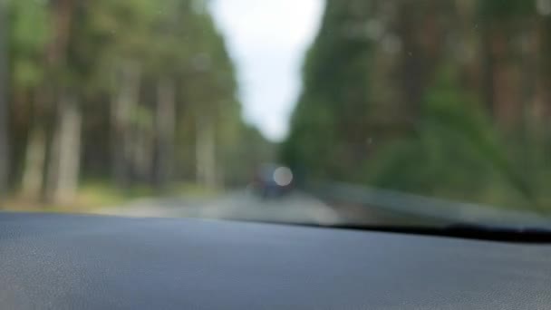 Vue floue par la fenêtre avant de la voiture. La voiture va sur une route de campagne. 4K — Video