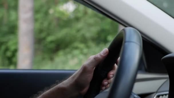 Man zijn auto rijden. Rijdende auto op vakantie, natuur. Mannenhand op stuurwiel close-up. 4k — Stockvideo