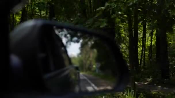 Veja o espelho retrovisor como passeios de carro na estrada rural. 4K — Vídeo de Stock