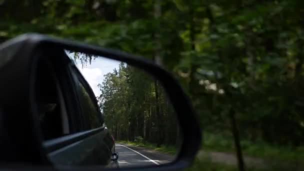 当汽车在乡村道路上行驶时, 可以看到后视镜。4k — 图库视频影像