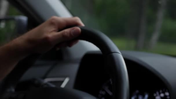 Un hombre conduciendo su auto. Conducir coche en vacaciones, la naturaleza. Hombre Mano en el volante de cerca. 4K — Vídeo de stock