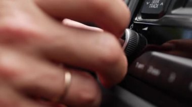 Bir alyans ile erkek el otoyol müzik dinleme büyük şehirde commuting seyahat günü araba içinde radyo hacmi dönüm. Araç ses sisteminde ses seviyesi ayarı. Closeup. 4k