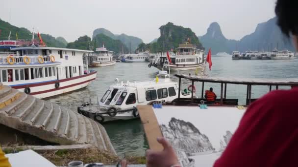 HALONG BAY, VIETNAM - 25 DE MARZO DE 2019: Artista dibuja tinta sobre papel acuarela en la bahía en el fondo de los barcos. 4k — Vídeos de Stock