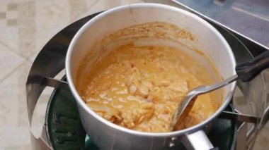 Adım adım tom yam çorbası pişirme. Tavuk fileto biber ezmesi ile kaynayan hindistan cevizi sütü eklendi. Tay mutfağı. Closeup. 4k