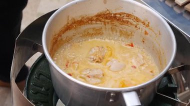 Adım adım tom yam çorbası pişirme. Tavuk fileto biber ezmesi ile kaynayan hindistan cevizi sütü eklendi. Tay mutfağı. Closeup. 4k