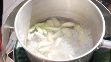 Limon otu ve zencefil bir tencerede kaynar su. Adım adım Tom Kha Gai çorbası pişirme. Tay mutfağı. Closeup. 4k