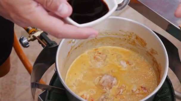 Cook aggiunge salsa di soia alla pentola bollente di zuppa speziata tailandese. Zuppa di patate filate di cottura passo dopo passo. Cucina thailandese. Primo piano. 4k — Video Stock