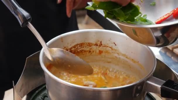 Крок за кроком приготування їжі Том ям суп. Гострий перець чилі і трави додаються до киплячого супу. Тайської кухні. Крупним планом. 4K — стокове відео