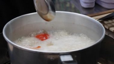 Adım adım limon otu, galangal, kaffir kireç yaprakları, taze biber, kireç, hindistan cevizi sütü ile Tom Kha Gai çorbası pişirme. Otantik Tay tarzı yemekler. Closeup. 4k
