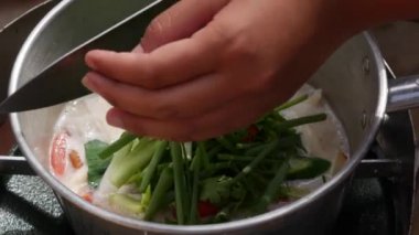 Adım adım limon otu, galangal, kaffir kireç yaprakları, taze biber, kireç, hindistan cevizi sütü ile Tom Kha Gai çorbası pişirme. Otantik Tay tarzı yemekler. Closeup. 4k